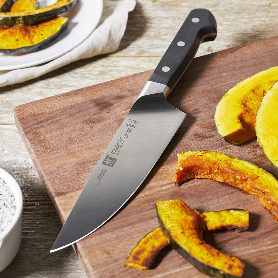 Chef’s Knife on a wooden cutting board with sliced pears – durable German-made kitchen knife for precise cutting.